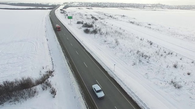 航拍卡车在雪地里行驶的冬季道路。视频素材