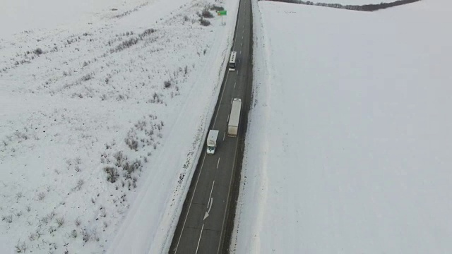 航拍车辆和公共汽车在雪地里行驶的冬季道路。视频素材