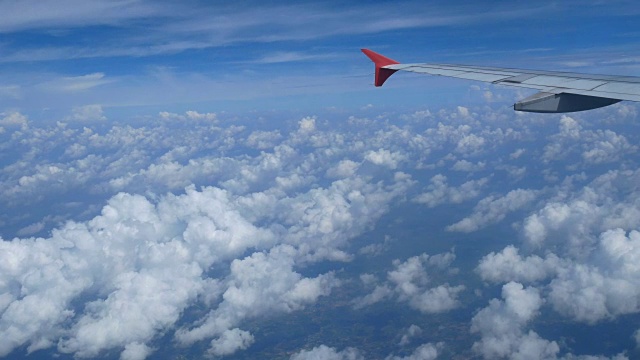 4 k。乘飞机旅行。从飞机窗口鸟瞰。机翼飞机和美丽的白云在蓝天为背景视频素材