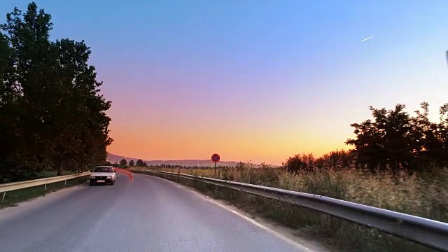 开车在乡村的道路上朝着日出，电影pov与充满活力的色彩视频素材