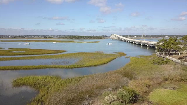 一架无人机在北卡罗来纳州翡翠岛海岸内水域平静的沼泽水域上空翻转视频素材