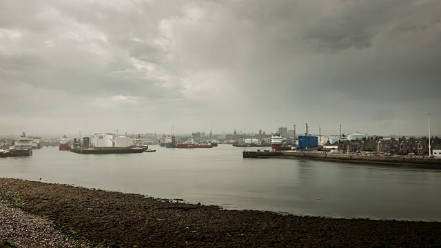 一场阵雨和昏暗的天空逾越了香港仔繁忙的工业海港，远处是城市的天际线视频素材