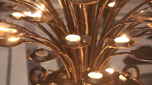 烛台一种古老的金属烛台，上面有燃烧的蜡烛教堂里祈祷的地方视频素材