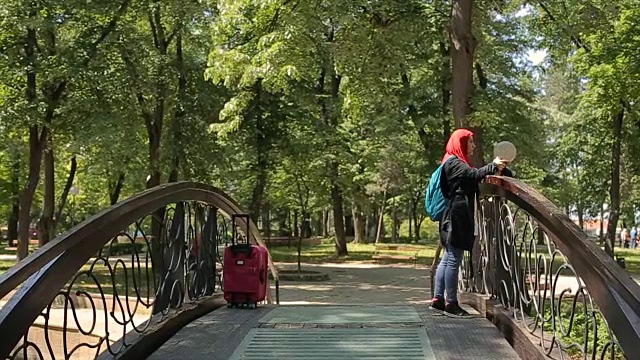 阿拉伯妇女站在桥上拍照，旅行的概念视频素材