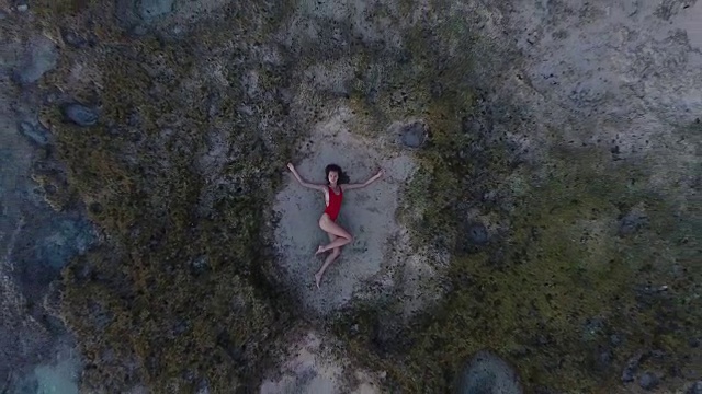 美丽的年轻女子躺在巴厘岛海滩的沙滩上视频素材