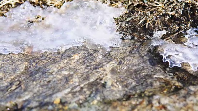 流过岩石上融化的雪的清冷的水流。视频素材