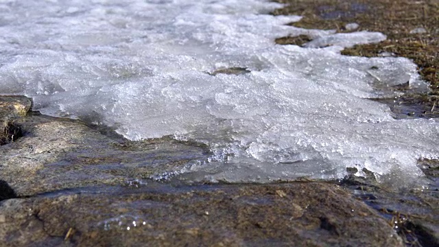 流过岩石上融化的雪的清冷的水流。视频素材