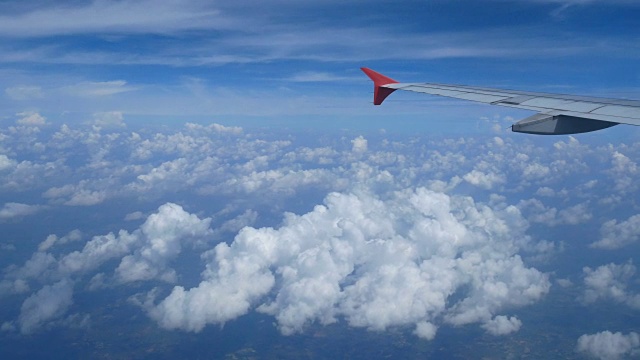 4 k。乘飞机旅行。从飞机窗口鸟瞰。机翼飞机和美丽的白云在蓝天为背景视频素材