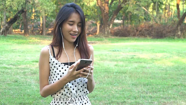 可爱的女人随着音乐的节拍听着跳舞。视频素材