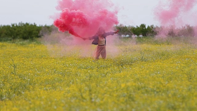 美丽的女人在草地上，手里拿着燃烧的火把视频素材