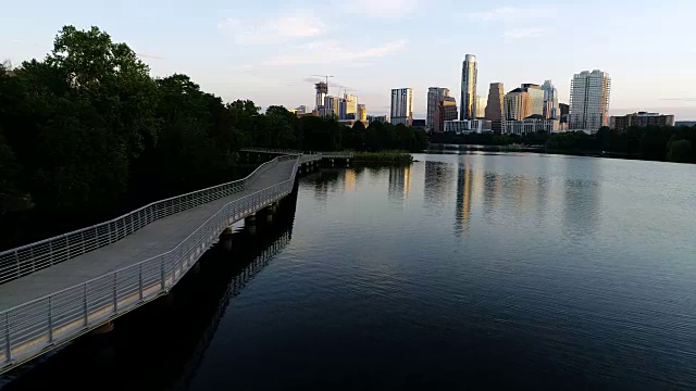 完美的日出天际线城市景观向前移动在德州奥斯汀河畔人行天桥低而缓慢视频素材