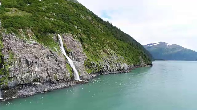 一架无人机沿着阿拉斯加惠蒂尔威廉王子湾的海岸悬崖和瀑布飞行视频素材