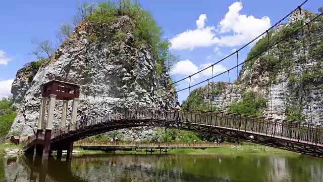 4K:人群在桥上行走的时间延时，在夏天的风景在山脉和深蓝色的天空视频素材