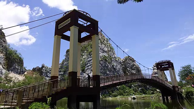 4K:人群在桥上行走的时间延时，在夏天的风景在山脉和深蓝色的天空视频素材