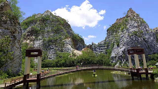 4K:人群在桥上行走的时间延时，在夏天的风景在山脉和深蓝色的天空视频素材