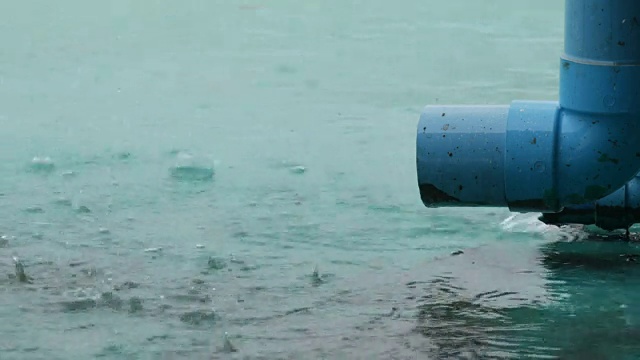 大的蓝色雨管，雨水顺着它排出去。热带降雨视频素材