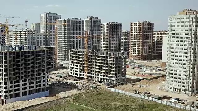 鸟瞰图。建设一个现代化的小区，拥有住宅公寓和发达的基础设施。一个有起重机和高楼的建筑工地。房地产买卖及租赁视频素材