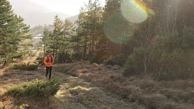 男跑步者在阳光下跑上美丽的山道视频素材