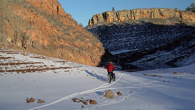 一名男性骑着一辆胖胖的山地车在雪道上视频素材