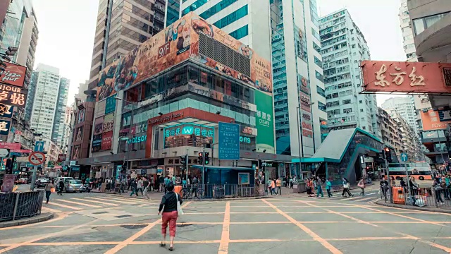 香港交通及建筑的时间间隔。汽车和公共汽车在路上行驶。在大城市的高峰时间，人们在人行横道上行走。视频素材