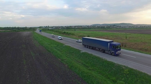 航拍卡车行驶在田野间的道路上。视频素材