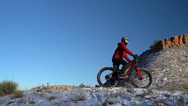 一名男性骑着一辆胖胖的山地车在雪道上视频素材