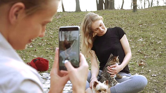 Selfy。一个肩上扛着一只猫的女孩带着一个女孩和一只狗视频素材