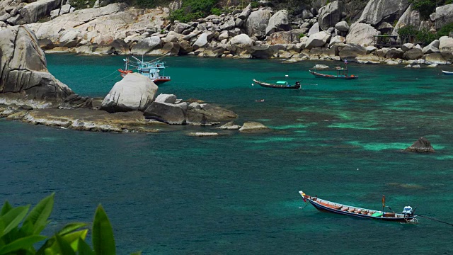 天晴的Tanote湾。长尾船和一艘潜水船停泊在泻湖里。游客们在浅水里浮潜。Koh道、泰国视频素材