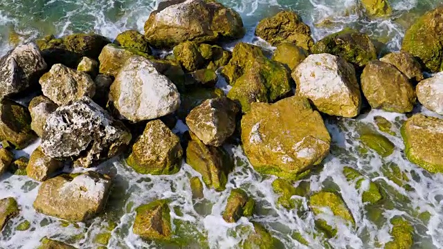 大浪冲击石海岸的绿松石海与水晶清澈的水视频素材