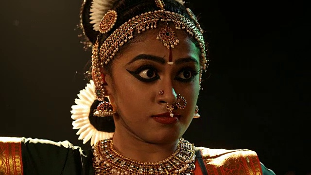 美丽的年轻女子在表演bharatanatyam舞蹈/印度时眼神迷离视频素材