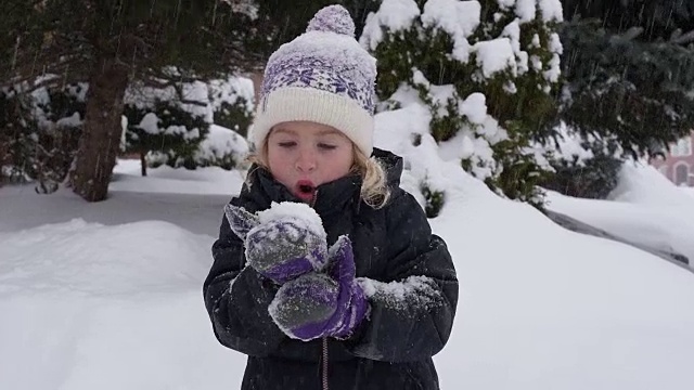 小女孩把手里的雪吹飞了视频素材