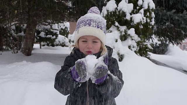 小女孩把手里的雪吹飞了视频素材