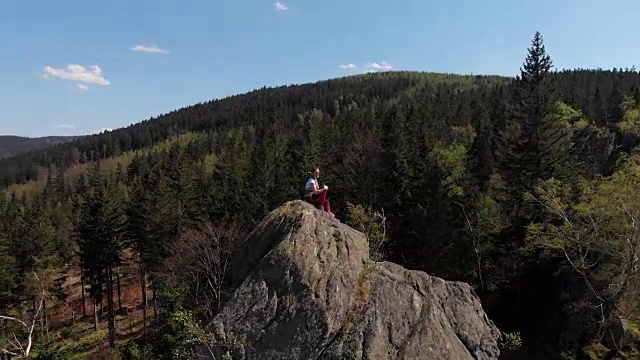 成功的年轻女子双手高举在山顶。视频素材