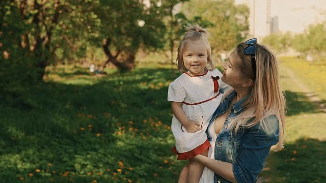 妈妈和女儿在公园散步，漂亮的妈妈带着孩子们在户外视频素材