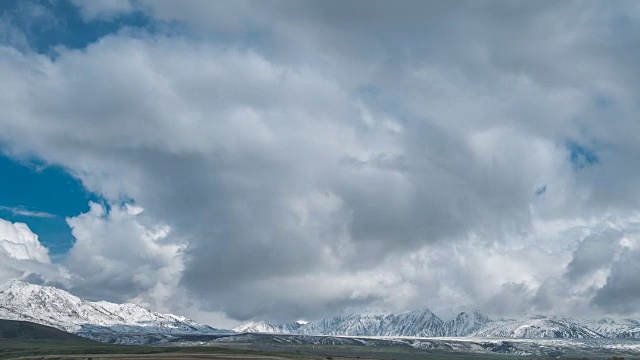 哈萨克斯坦白雪皑皑的山峰上，蓝天白云。间隔拍摄FullHD视频素材