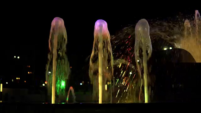 夜间喷泉中五彩缤纷的水流，动作超慢。视频素材