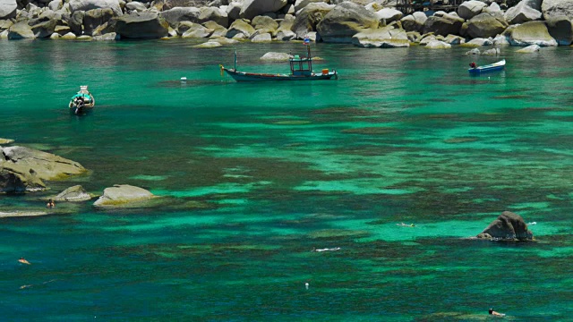 游客们在碧蓝的海水中浮潜。一些长尾船的背景。Koh道、泰国视频素材