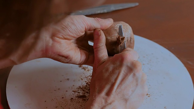 在陶艺车间，专业陶工用专用工具制作干陶土杯视频素材