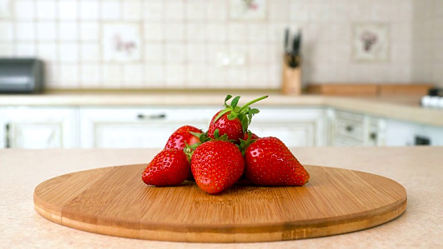 近距离观察整个新鲜草莓。以白色厨房为背景的旋转相机。Dolly-shot。视频素材