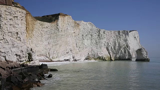 英国东苏塞克斯海福德附近的白色白垩峭壁，海浪拍打着悬崖和蓝色的大海和天空视频素材