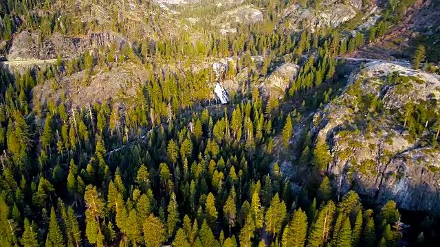 无人机俯瞰巨大的森林地面与瀑布和内华达山脉荒野景观日出在翡翠湾，太浩湖，加利福尼亚州视频素材