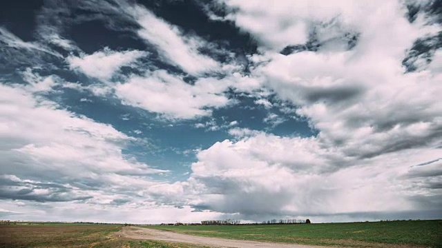 Time Lapse Time- Lapse Time- Lapse Of Rural Road Through Field Spring Meadow Landscape Under Scenic Dramatic Sky With Fluffy Clouds Before Rain.乡村乡村路穿过田野春天草地景观。农业和天气预报概念视频素材