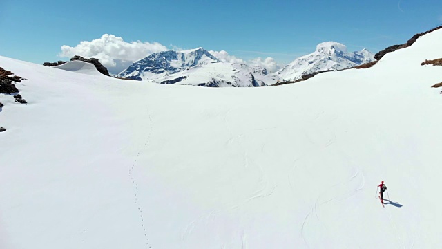 空中飞行:飞过正在走向雪山山顶的徒步旅行者视频素材