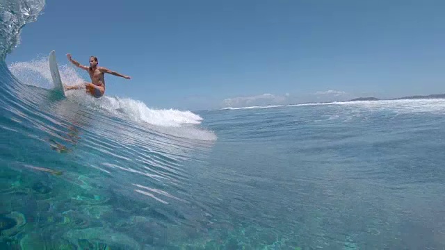 慢动作:酷酷的冲浪者雕刻一个大的云破浪在一个完美的夏日。视频素材