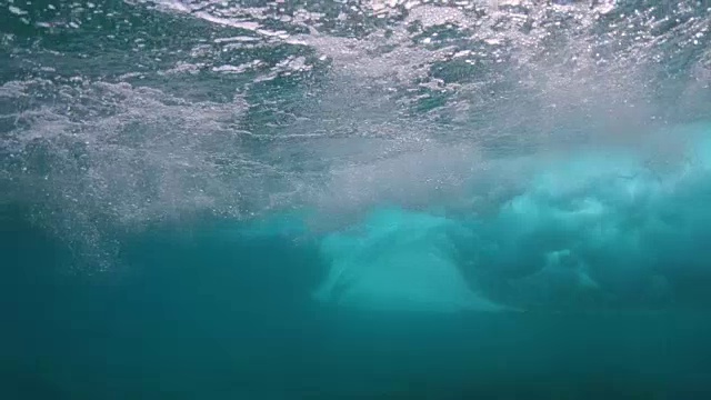 水下:强大的深蓝色桶状海浪将无法辨认的冲浪者推向岸边视频素材