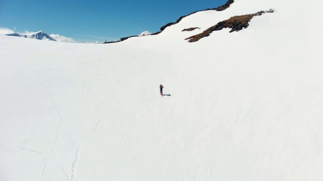 空中飞行:飞过正在走向雪山山顶的徒步旅行者视频素材