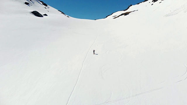 空中飞行:飞过正在走向雪山山顶的徒步旅行者视频素材