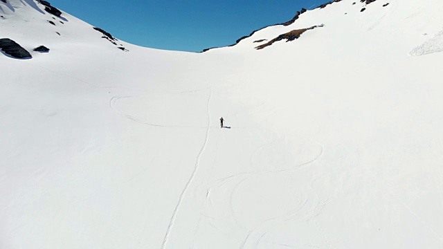 空中飞行:飞过正在走向雪山山顶的徒步旅行者视频素材