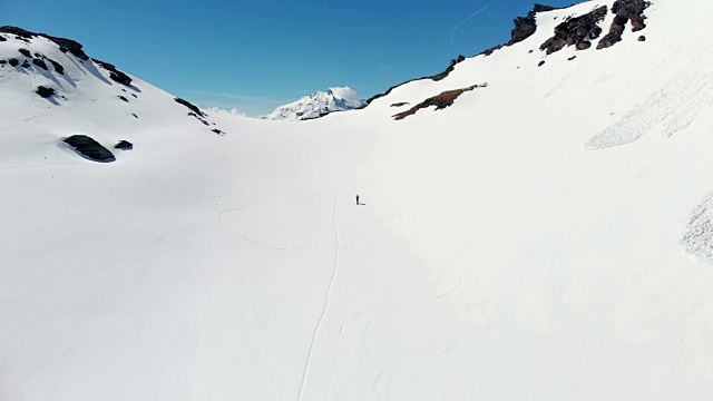 空中飞行:飞过正在走向雪山山顶的徒步旅行者视频素材