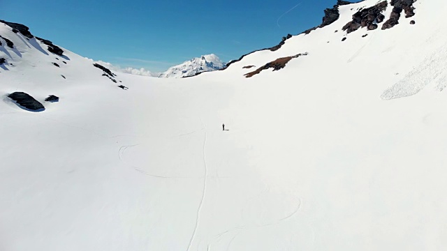 空中飞行:飞过正在走向雪山山顶的徒步旅行者视频素材